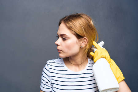 Cleaning lady with detergent home care service delivery gray backgroundの写真素材