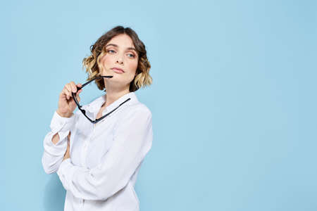 Business woman in a light shirt on a blue background gestures with her hands emotions model workの写真素材