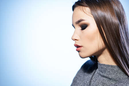 attractive woman bright makeup straightens her hair with hand elegant style modelの写真素材