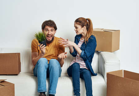Married couple in new apartment moving boxes with joy things
