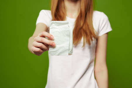 girl with pad on green background menstruation critical days cropped view white t-shirtの写真素材