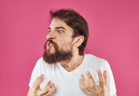 Surprised man on pink background gesturing with hands cropped view of modelの写真素材