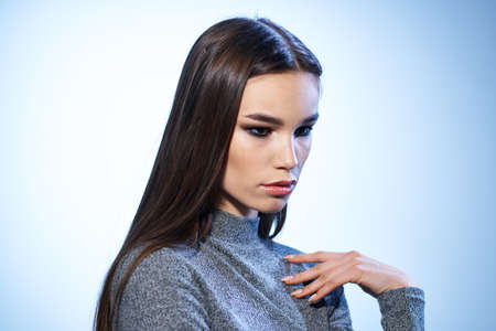 Pretty woman in gray sweater bright makeup long hair charm cropped view