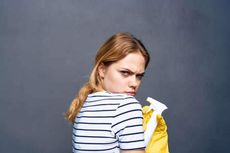 Cleaning lady in yellow rubber gloves detergents home care gray backgroundの写真素材