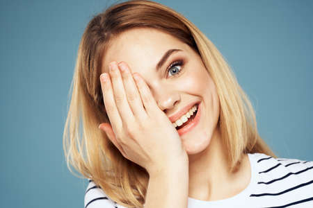 Blonde girl in striped t-shirt lifestyle blue background fun