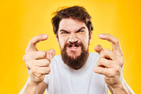 bearded man gesturing with hands studio lifestyle discontent yellow backgroundの写真素材