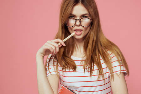 beautiful female student holding books education institute gesturing with hands pink background Copy Spaceの写真素材