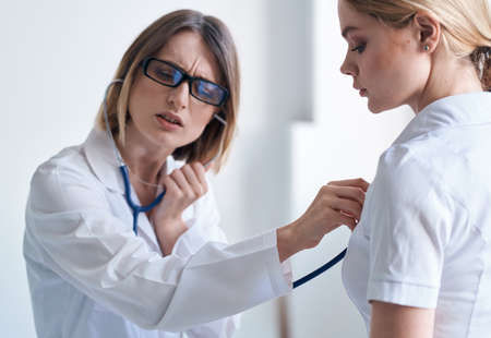 Doctor and patient on light blue background stethoscope health problems cropped view