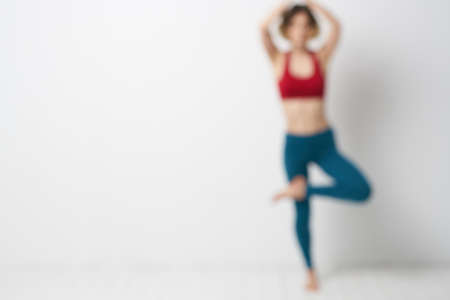 A woman in full growth In a bright room yoga meditation is engaged in sportsの写真素材