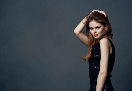 Woman on gray background in black dress cropped view Copy Space