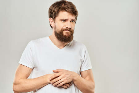man in white t-shirt gesturing with his hands studio dissatisfaction lifestyle light backgroundの写真素材