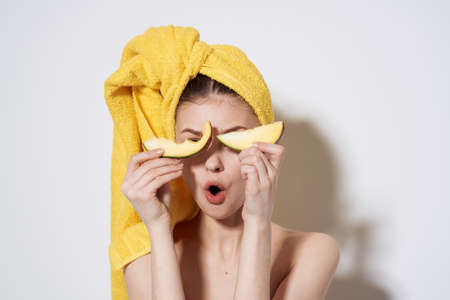 Woman with mango in hands bared shoulders towel on head exotic fruits bared shouldersの写真素材