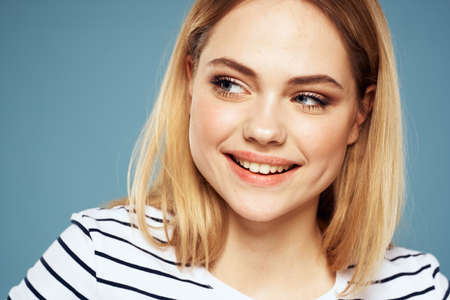 Blonde girl in striped t-shirt lifestyle blue background fun