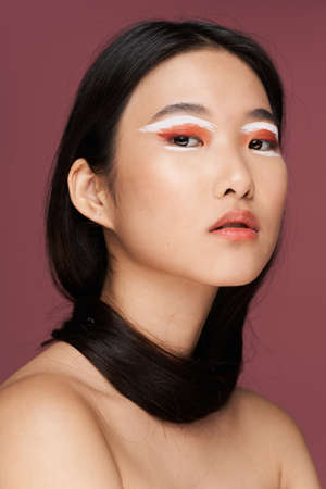 Woman with bright makeup naked shoulders asian appearance