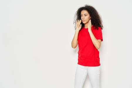 Beautiful brunette with curly hair and in a red T-shirt on an isolated background ,Copy Spaceの写真素材