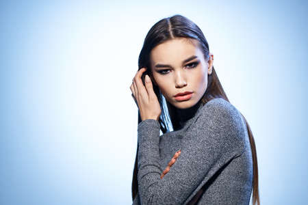 attractive woman bright makeup straightens her hair with hand elegant style model