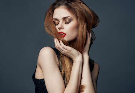 red-haired lady in a black dress with red lips and eye shadow