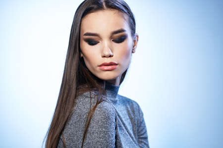 Pretty woman in gray sweater bright makeup long hair charm cropped view