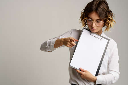 Business woman with folder of documents in hands on gray background cropped view of workの写真素材
