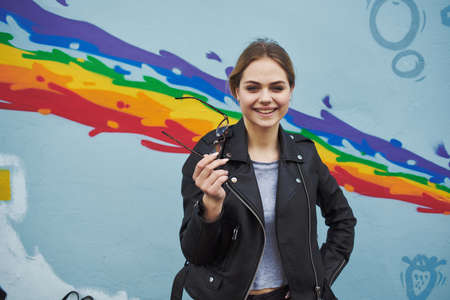Women near the graffiti on the wall in the form of a rainbowの写真素材