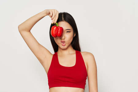 Woman holding red pepper near face slim figure healthy eating vegetarianの写真素材