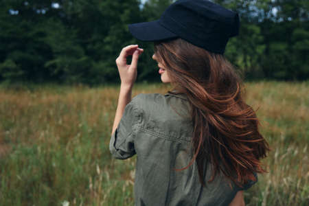 Woman in a cap with long hair Green shirt natureの写真素材