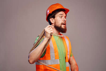 Male builder orange hard hat work Professional gray backgroundの写真素材