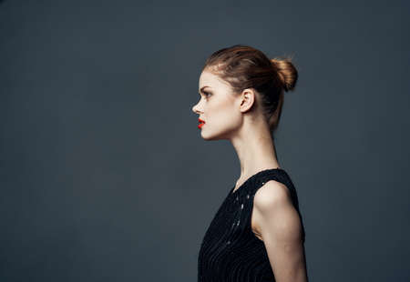Side view of beautiful woman in black dress with hairstyle
