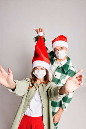 Young couple together New Years medical masks Merry Christmas funの写真素材