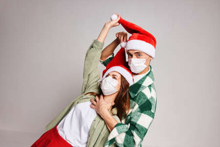 man or woman wearing christmas hats holiday medical masks