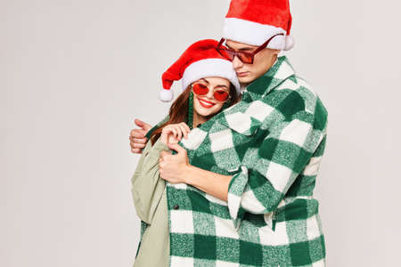 A man and a woman are hugging together in Christmas hats, sunglasses, holiday togetherの写真素材
