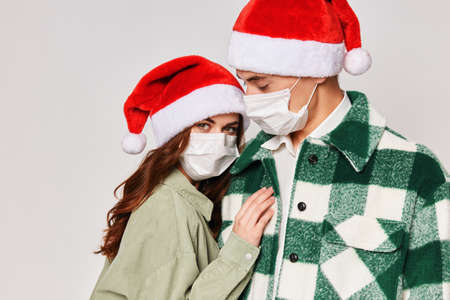man and woman in medical masks protection hugs together friendship new year holidayの写真素材
