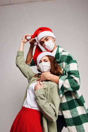 Man smothers woman Christmas hats Merry Christmas medical holiday masksの写真素材