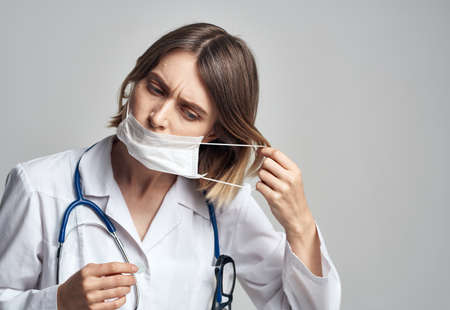 Professional doctor nurse in a gown with a stethoscope and a medical maskの写真素材