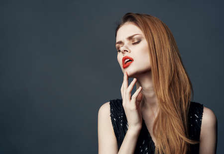 Portrait of a beautiful woman gesturing with her hands gray background cropped view close-up