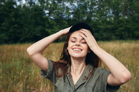 A woman in a shirt on the meadow touches her faceの写真素材