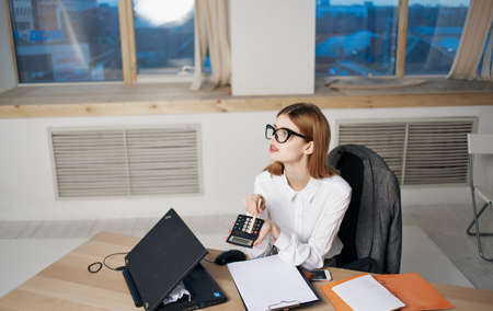 woman secretary in office at work desk documents