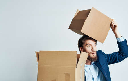 Man in a suit emotions work moving boxes on the floor