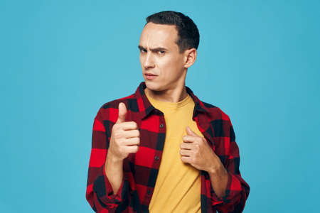 A man in a plaid shirt shows thumb up emotions displeasureの写真素材