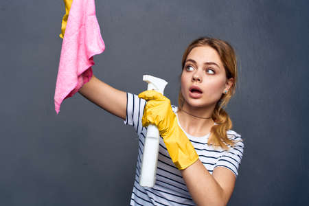 cleaning lady with pink rag in hand home care service gray background