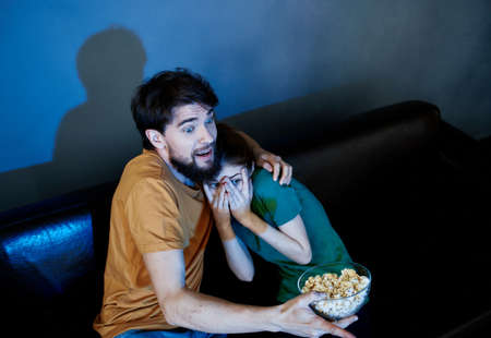 emotional man and woman watching tv indoorsの写真素材