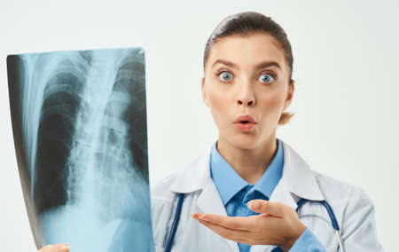 doctor with x-ray and medical gown light background stethoscope