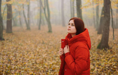 Woman in red jacket Autumn leaf walk fresh airの写真素材