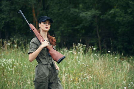 Military woman Shotguns on the shoulder black cap hunting lifestyle green overallsの写真素材