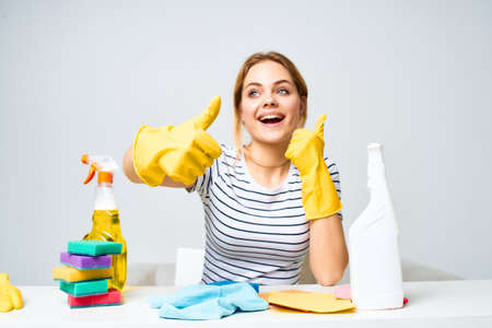 Woman sitting at the table rubber gloves cleaning housework detergent serviceの写真素材