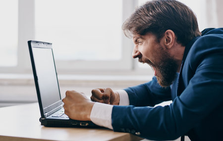 business man at his desk in a suit in front of laptop communication office professional
