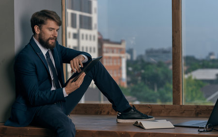 business man in the office with a tablet in his hands near the window Professionalの写真素材