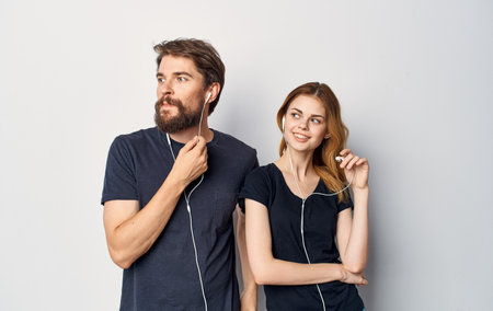 young couple in black t-shirts with headphones listening to music technology lifestyle
