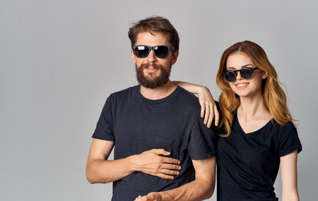 young fashion couple wearing sunglasses chatting hug romance studio isolated backgroundの写真素材