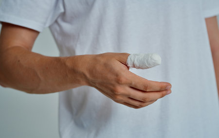 man in white t-shirt broken finger bandaged medicineの写真素材